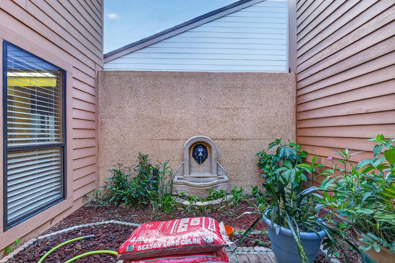 Enclosed courtyard with wall fountain and plantings at 3515 Cormorant Branch Ct, Jacksonville, FL