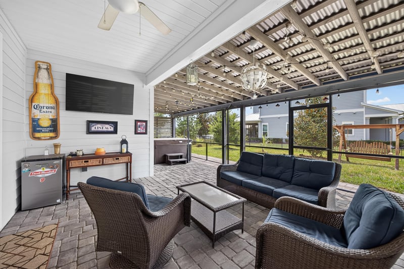Screened back porch with lounge seating and TV at 91 Tilloo Ct, St. Johns, FL