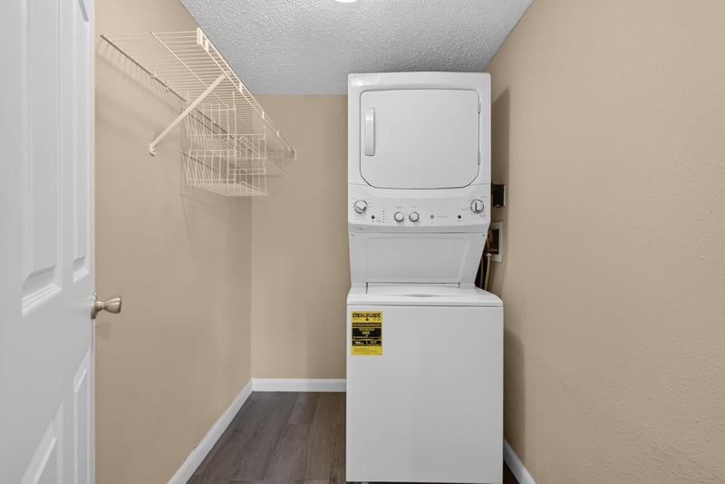 Stacked washer and dryer with shelving at 5811 Atlantic Blvd unit 47, Jacksonville, FL 32207