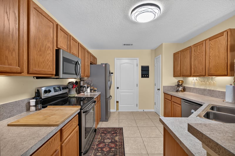Kitchen with wood cabinets and tile floor at 1589 Backwater Drive, Middleburg, FL 32068