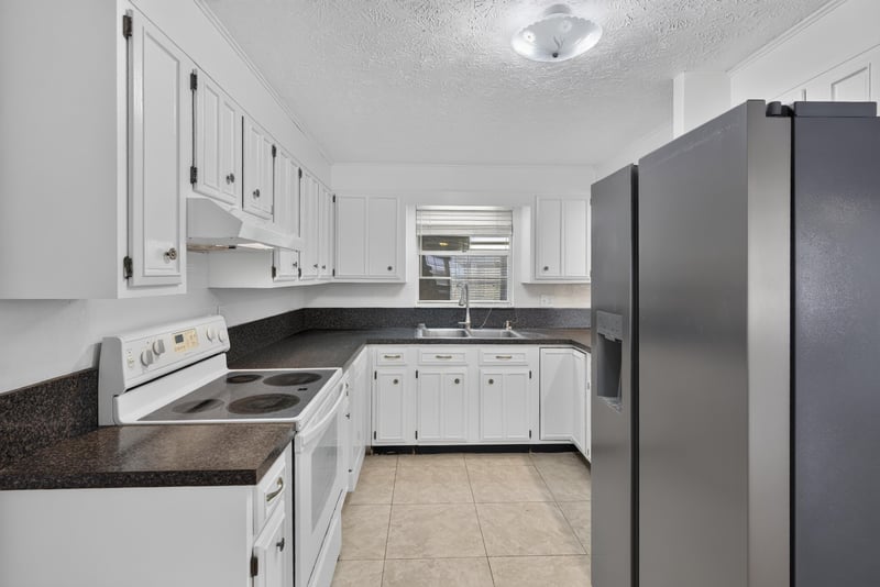 Kitchen with white cabinets and stainless refrigerator at 9954 Larkdale Ct, Jacksonville, FL 32257