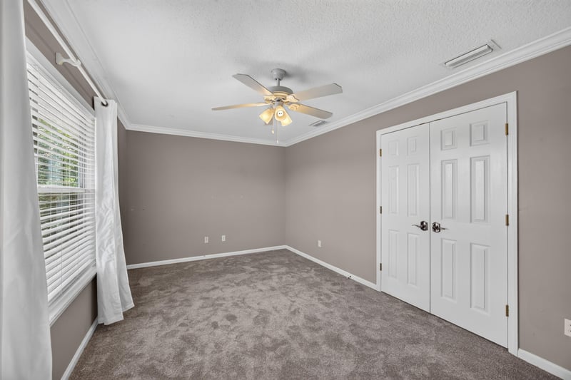 Bedroom with carpet and closet doors at 1493 Greyfield Dr, St. Augustine, FL 32092