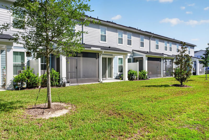 Rear exterior view of townhome row and lawn at 39 Mellowood Ln, St. Augustine, FL 32092