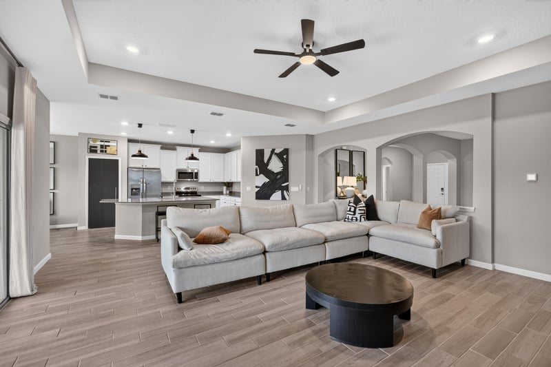 Living room open to kitchen with ceiling fan at 9942 Lovage Ln, Jacksonville, FL 32219