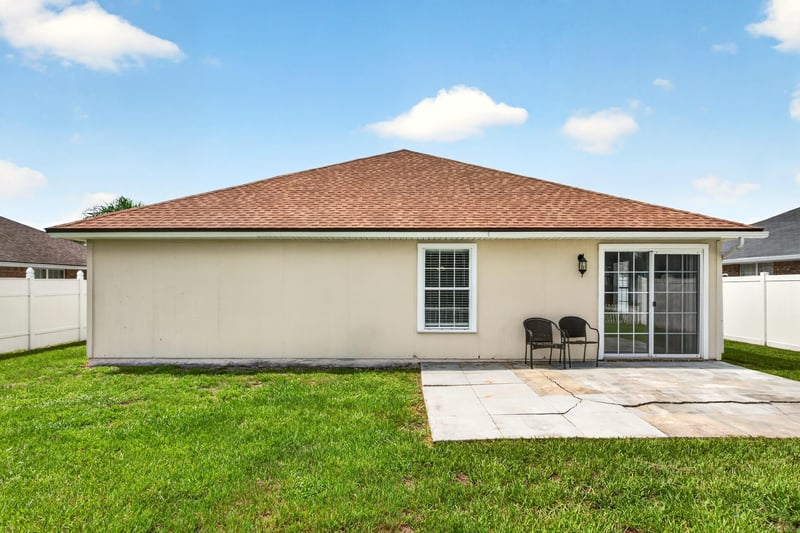 Back of home with sliding glass door and patio at 490 Hillside Dr, Orange Park, FL 32073