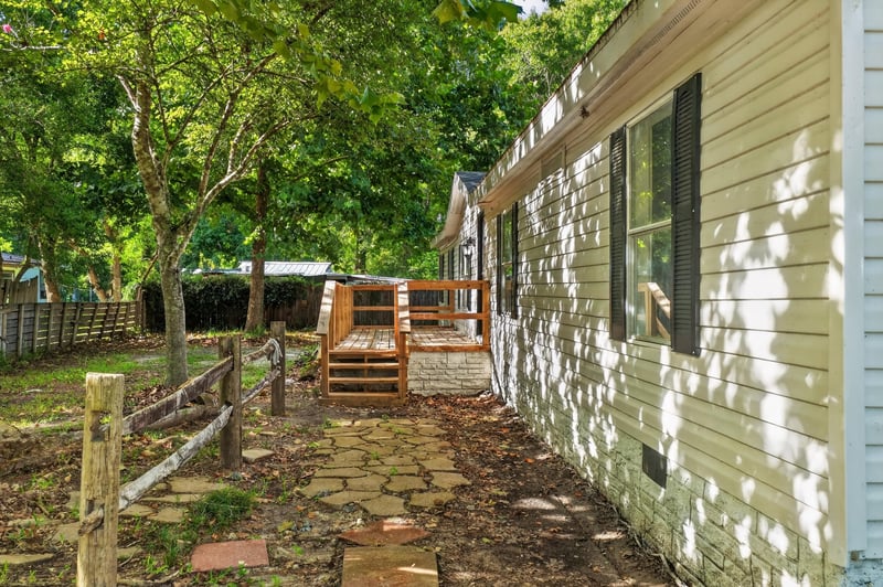 Side exterior with wood steps and shade trees at 55520 Jewel-Thomas Rd, Callahan, FL 32011