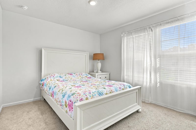 Bedroom with floral bedspread and nightstand at 8359 Zenith Cir, Jacksonville, FL 32256