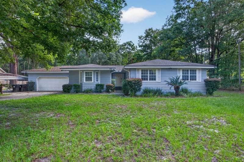 Front exterior with blue-gray siding and two-car garage at 892 Branscomb Rd, Green Cove Springs, FL