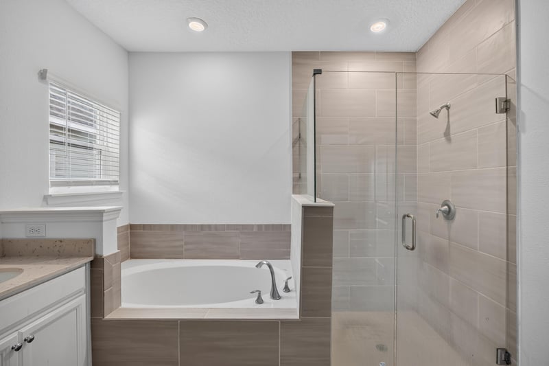Primary bathroom with glass shower and tub, virtually staged at 9905 Ansley Lake Dr, Jacksonville, FL