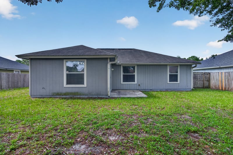 Backyard view of rear exterior and fence at 8519 Blazing Star Ct, Jacksonville, FL 32210