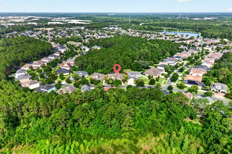 Aerial view of wooded subdivision with pin marking the home in Ponte Vedra Beach, FL