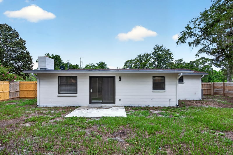 Backyard with rear door, AC unit, and fenced lawn at 184 Draco St, Orange Park, FL 32073