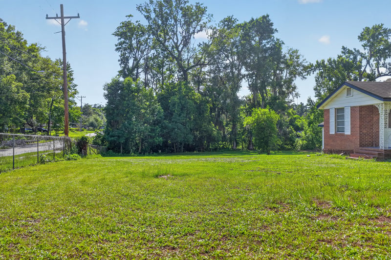 Open side yard with utility pole and trees at 5745 110th St, Jacksonville, FL 32244