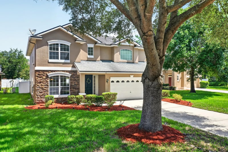 Front exterior with oak tree and landscaped lawn at 3660 Middlebrook Dr, Orange Park, FL 32065