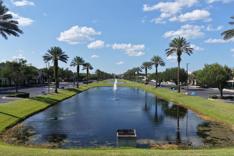 Pond with fountain beside palm-lined parking lot at 10550 Deerwood Park Blvd, Jacksonville, FL 32256