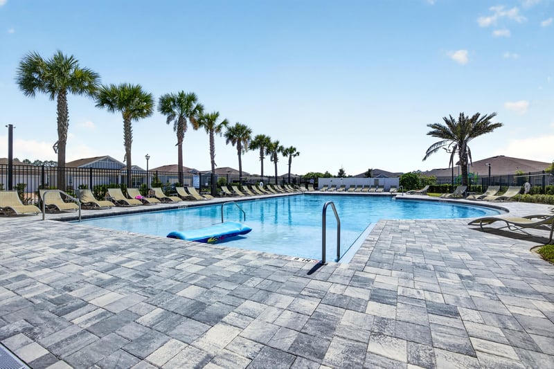 Community pool wide view with palm trees in Highland Chase