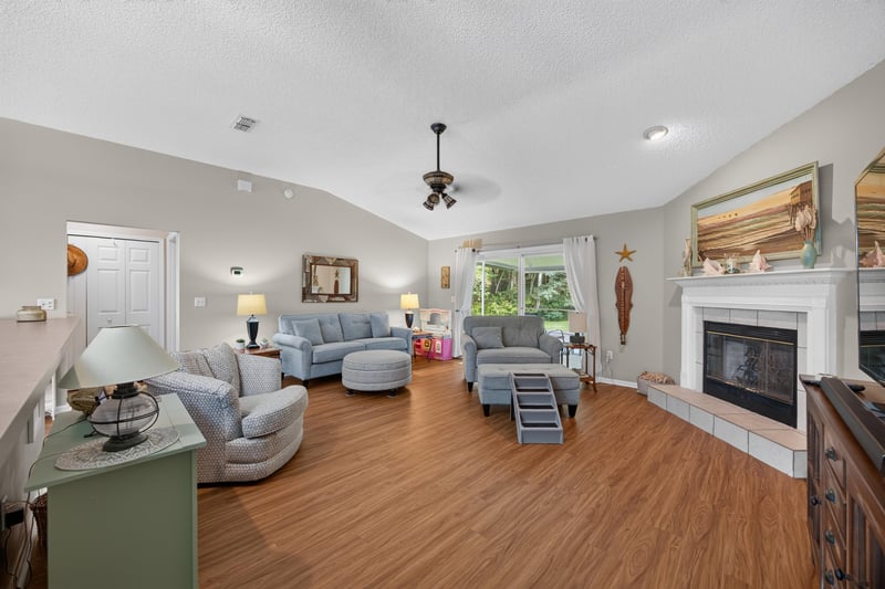 Wide view of living room with fireplace and wood floors at 13514 Las Brisas Way N, Jacksonville, FL