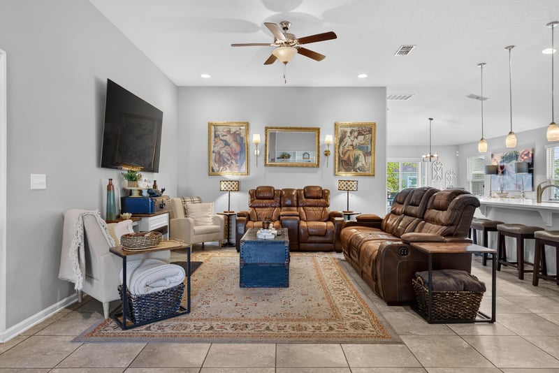 Living room with brown leather sectional and ceiling fan at 589 Seville Pkwy, St. Augustine, FL