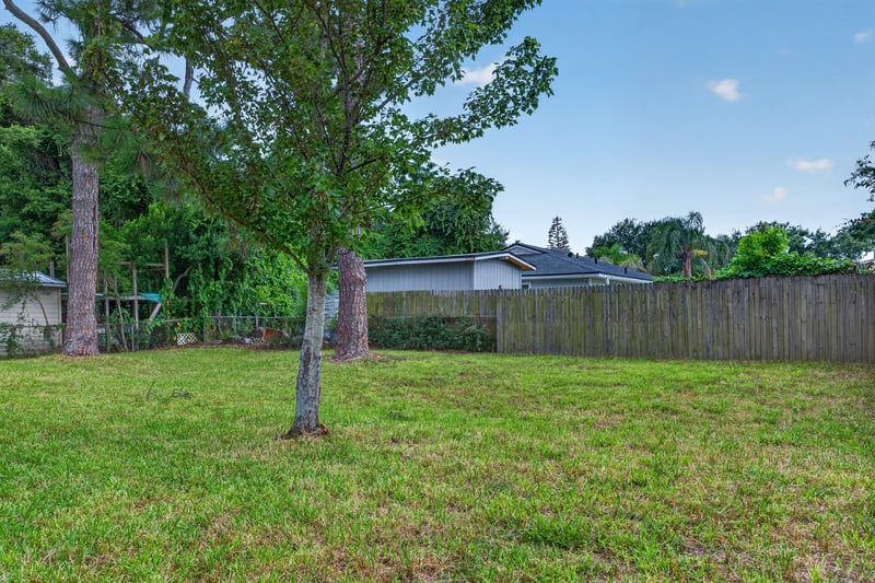 Fenced backyard with mature trees at 87 Saratoga Cir S, Atlantic Beach, FL