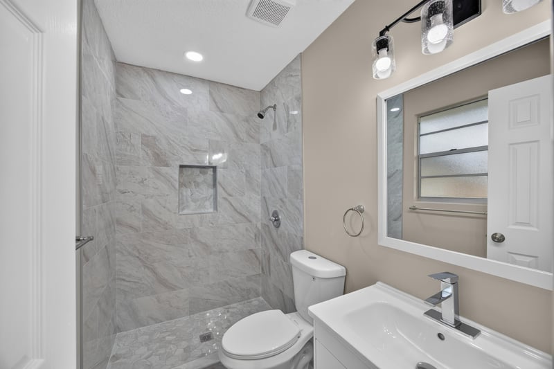 Bathroom shower with marble tile surround at 4117 Wilcrest Ct, Jacksonville, FL 32277