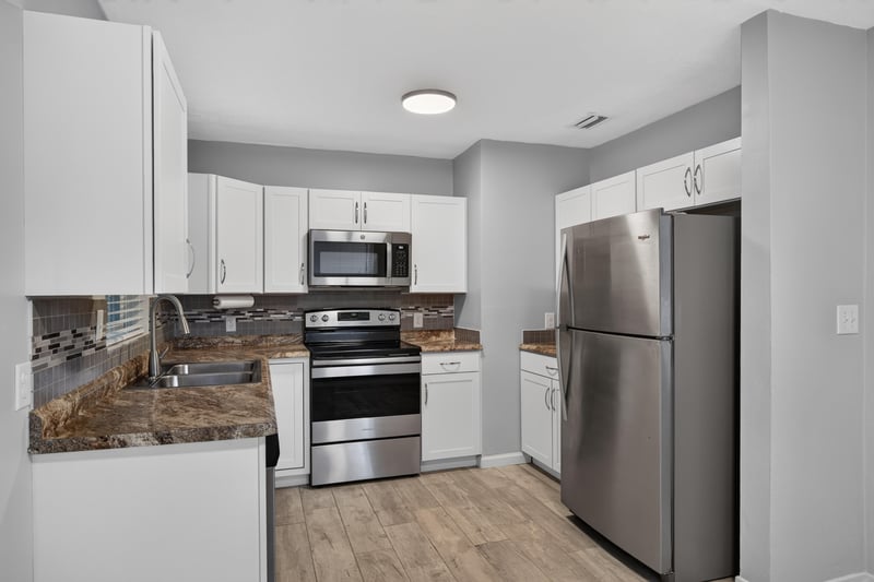 Kitchen, white cabinets and stainless refrigerator at 2256 Inwood Cir S, Jacksonville, FL