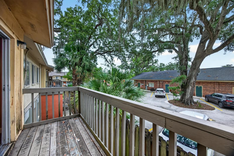 Balcony view with wood railing and oak trees at 1800 Park Ave apt 358, Orange Park, FL