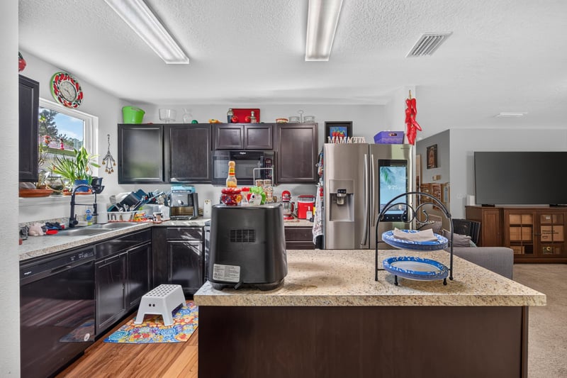 Kitchen island with granite counters and pendant lighting at 518 Matecumbe Ct, Macclenny, FL