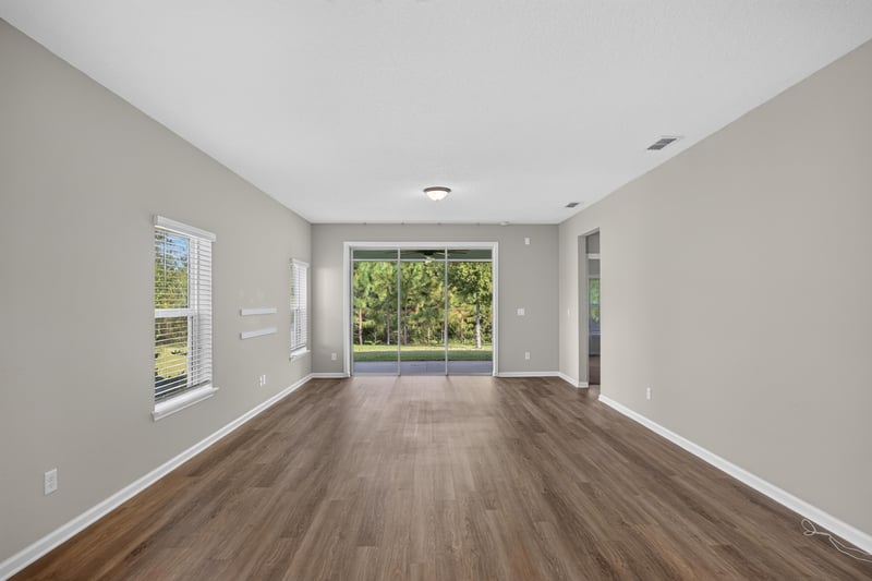 Living room with wood floor and sliding glass door at 75875 Saffron Ln, Yulee, FL 32097
