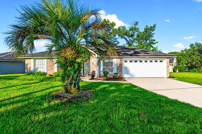 Front exterior with palm tree and driveway at 4556 Shaky Leaf Ln N, Jacksonville, FL 32224