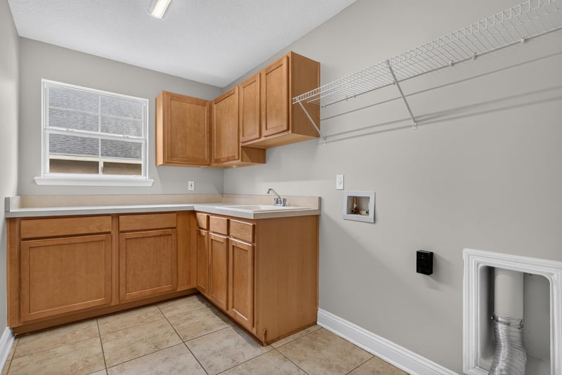 Laundry room with sink and wood cabinets at 4109 Eagle Landing Pkwy, Orange Park, FL 32065
