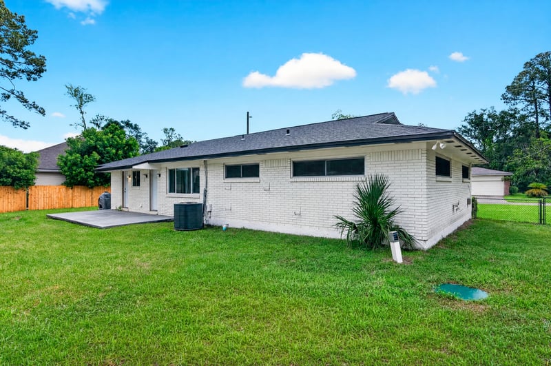 Backyard with open lawn and fencing at 9506 Harriet Ave, Jacksonville, FL 32208
