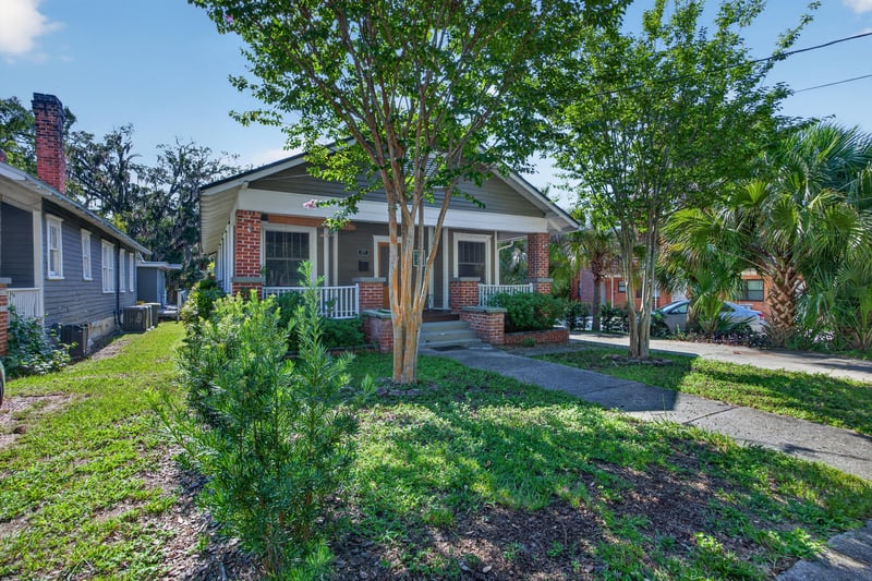 Front exterior wider view showing side yard and driveway at 1555 Belmonte Ave, Jacksonville, FL 32207