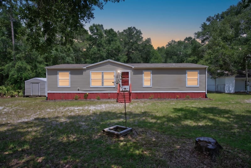 Day-to-dusk front exterior with red steps at 2549 Snapdragon Ave, Middleburg, FL 32068