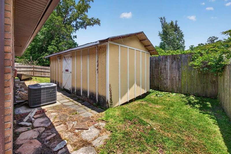 Backyard view with shed, AC unit, and stone path at 2460 San Sago Ln, Jacksonville, FL