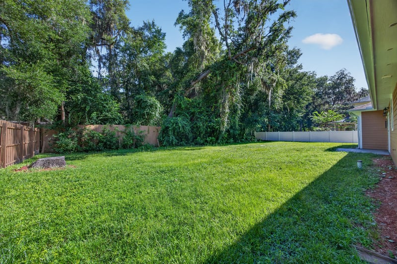 Backyard with grass lawn and tree line at 1012 Fruit Cove Rd, Jacksonville, FL 32259
