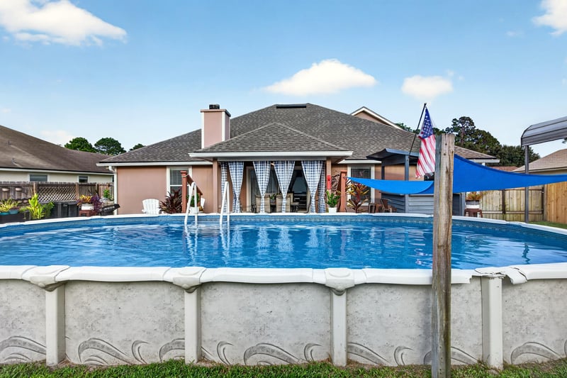 Above-ground pool with shade sail over patio at 3112 Silverado Cir, Green Cove Springs, FL 32043