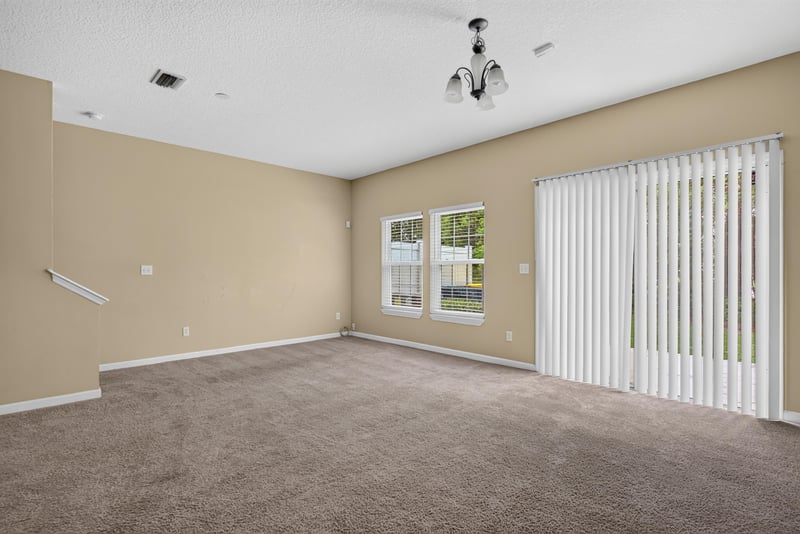 Living room corner with vertical blinds at 12359 Mangrove Forest Ct, Jacksonville, FL 32218
