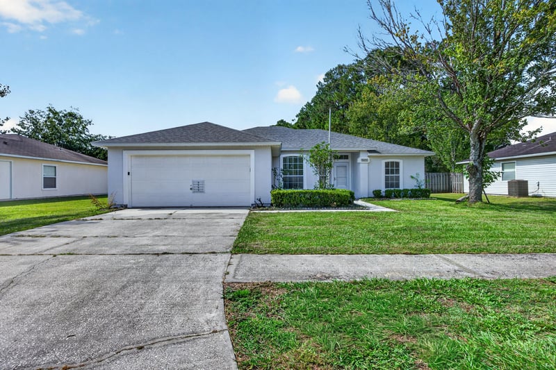 Front exterior with two-car garage and driveway at 9691 Nelson Forks Dr, Jacksonville, FL 32222