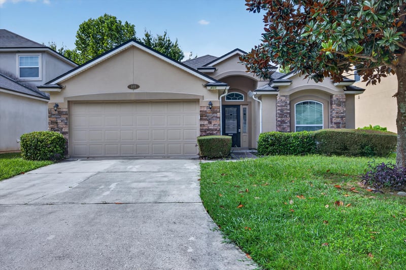 Front exterior with garage and shade tree at 469 Glendale Ln, Orange Park, FL