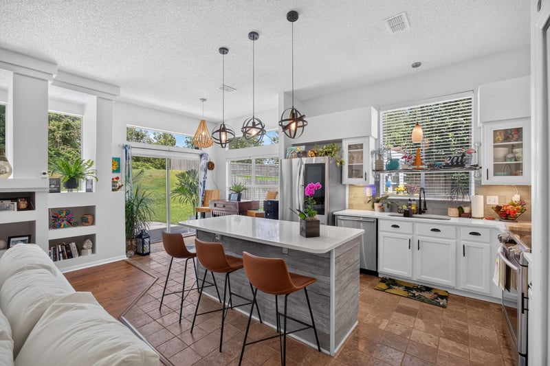 Kitchen island with bar seating and pendant lights at 1820 Burgess Hill Dr E, Jacksonville, FL