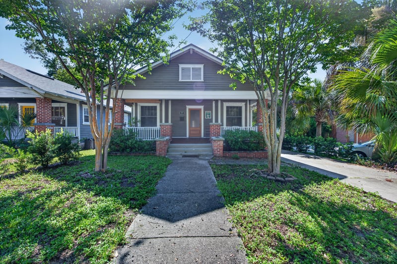 Front exterior of the gray craftsman bungalow with brick porch columns at 1555 Belmonte Ave, Jacksonville, FL 32207