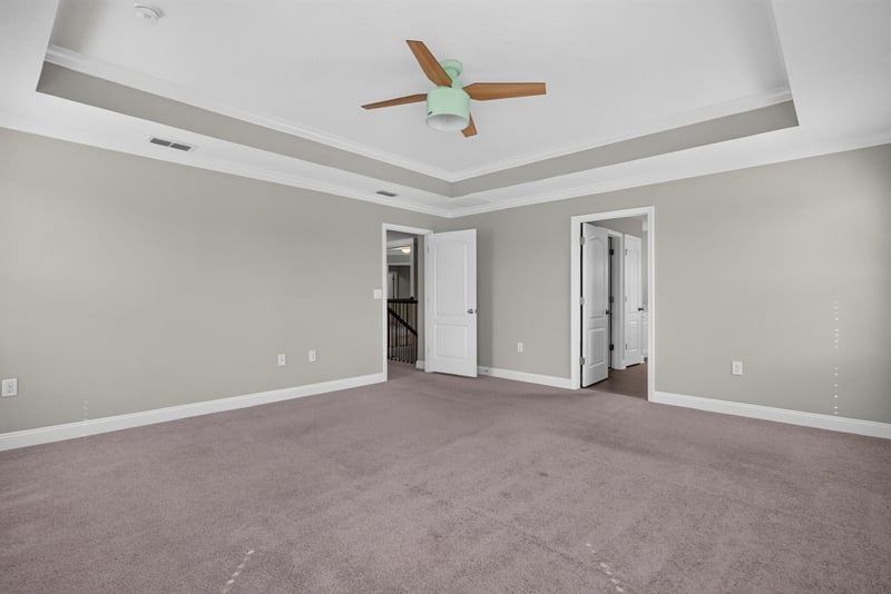 Bedroom corner with tray ceiling and two windows at 2580 Cold Stream Ln, Green Cove Springs, FL 32043