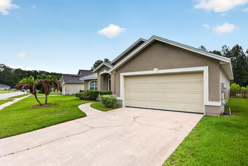 Front exterior with driveway and two-car garage at 706 Bonaparte Dr, Jacksonville, FL 32218