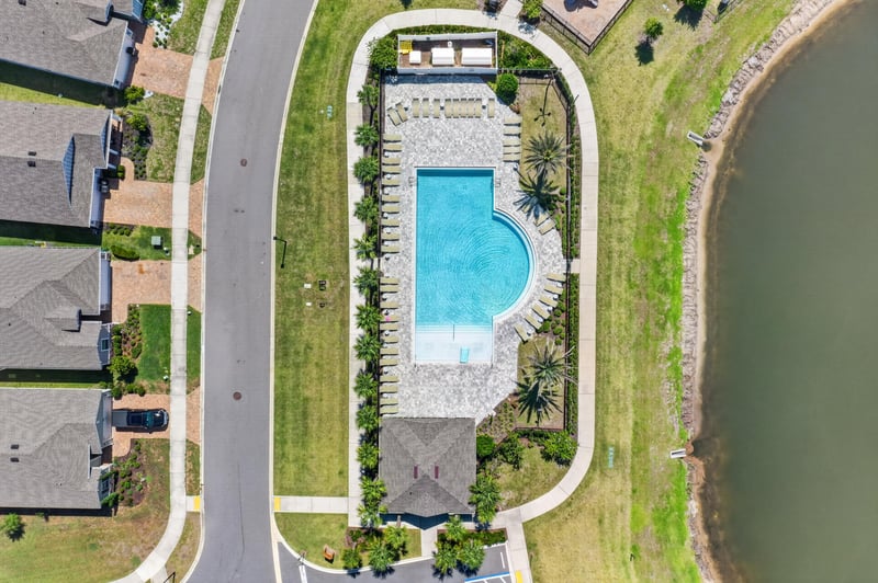 Drone view of community pool beside the lake in Highland Chase