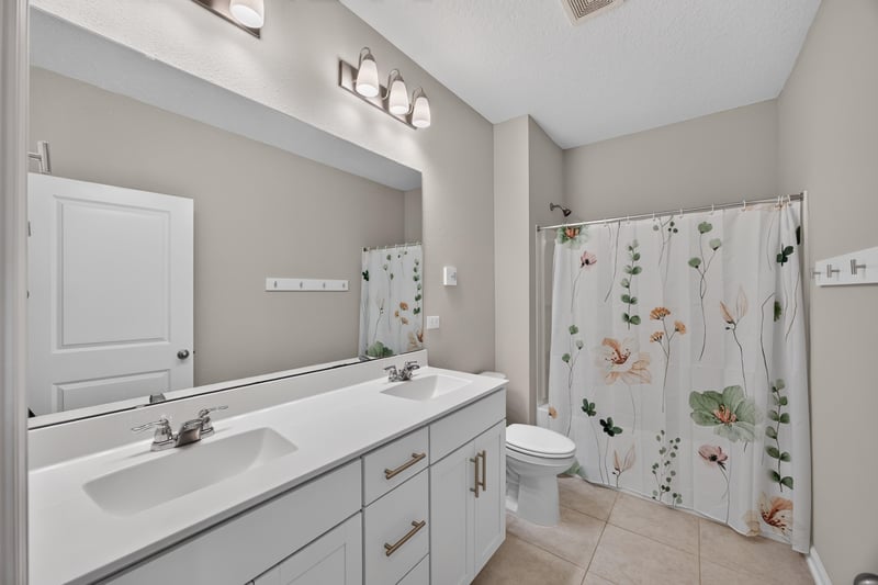 Bathroom with vanity, toilet and floral shower curtain at 75875 Saffron Ln, Yulee, FL 32097