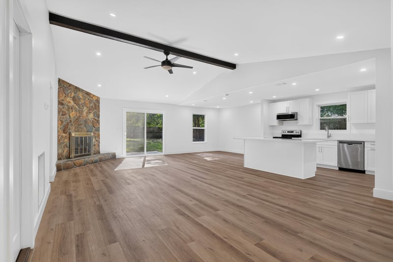 Open living area with stone accent wall and view into kitchen at 8453 Boysenberry Ln W, Jacksonville, FL