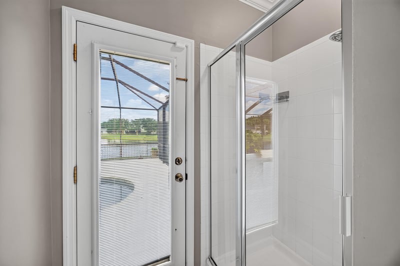 Bathroom with glass shower and door to patio at 1493 Greyfield Dr, St. Augustine, FL 32092