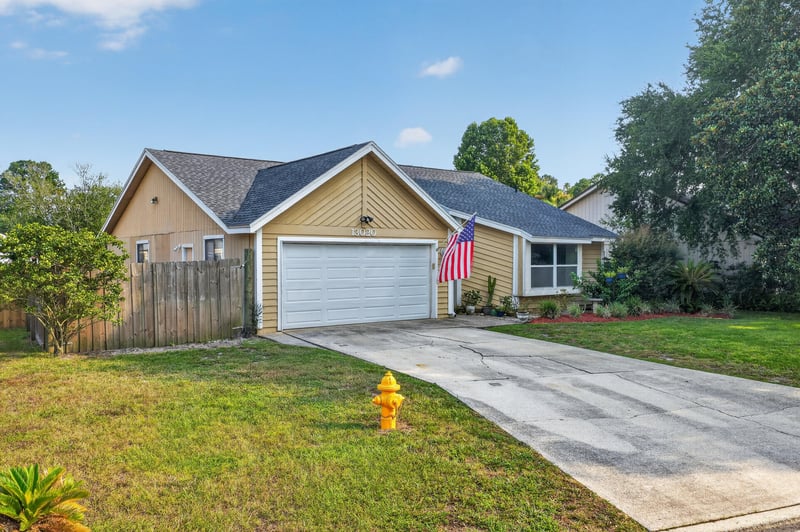 Front exterior with American flag and garage at 13020 Medford Ln, Jacksonville, FL 32225