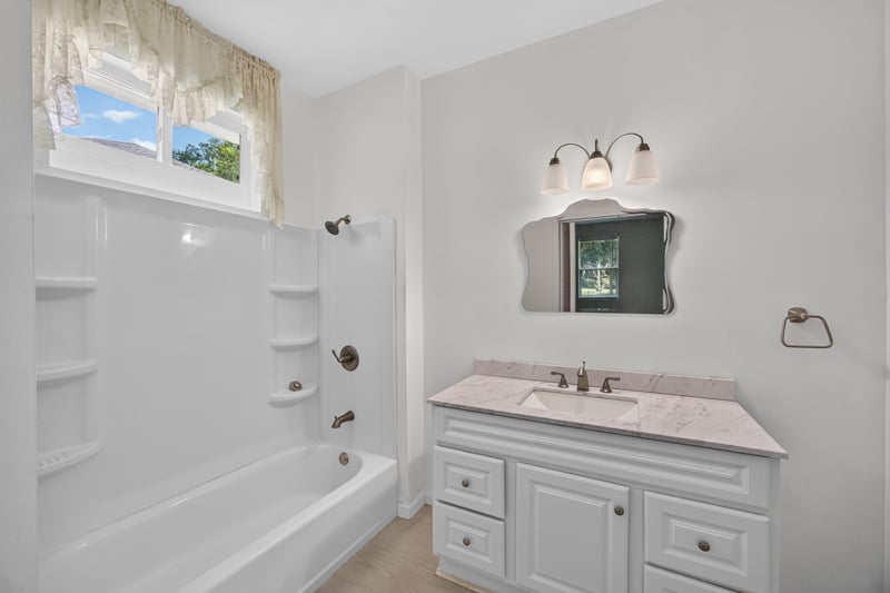 Bathroom with tub-shower and window above vanity at 1012 Fruit Cove Rd, Jacksonville, FL 32259