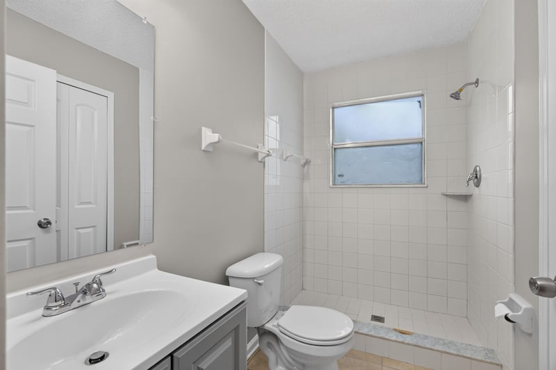 Bathroom with vanity, shower and window at 1040 Willow Cove Ct E, Jacksonville, FL 32233